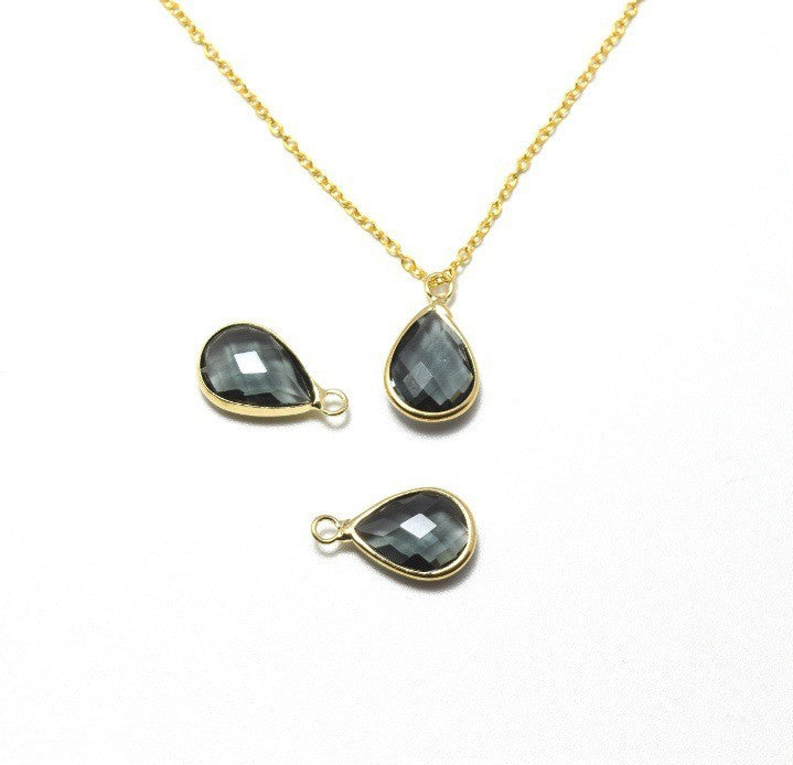 Vente au détail pendentif perle en verre à facettes gris 18x11x5mm avec contours dorés